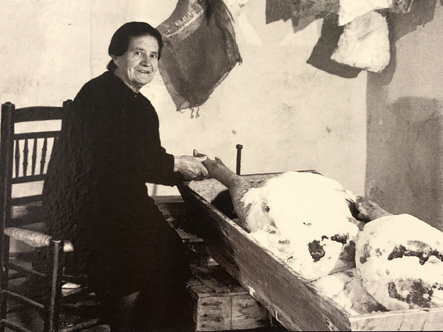 Fotografía de una mujer salando jamón (Museo del Jamón de Calamocha)