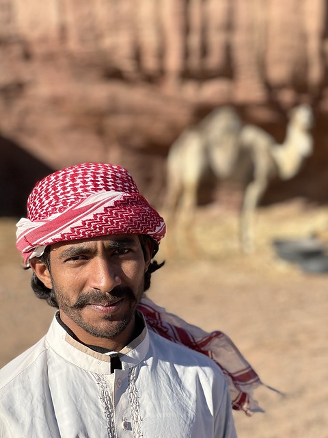 Hombre saudí con camello al fondo