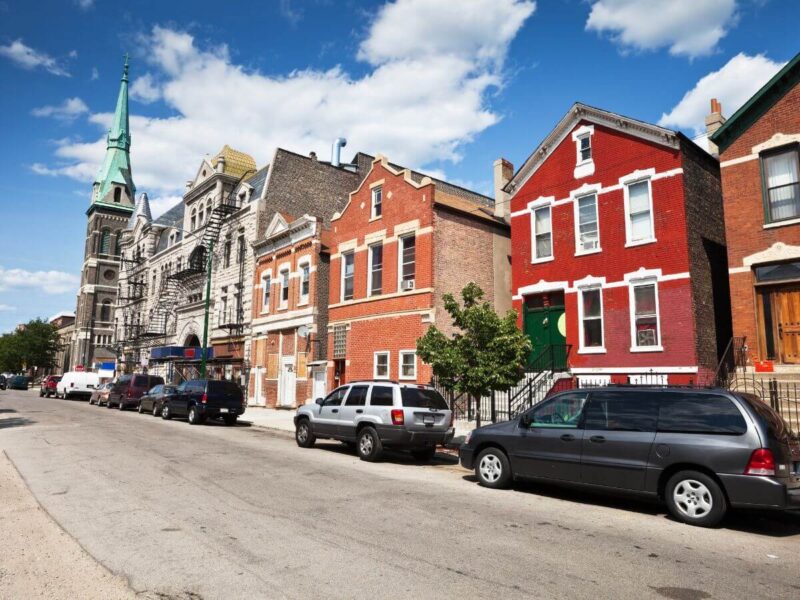 Calle de Chicago con casas y coches particulares y de alquiler aparcados junto a la calzada.