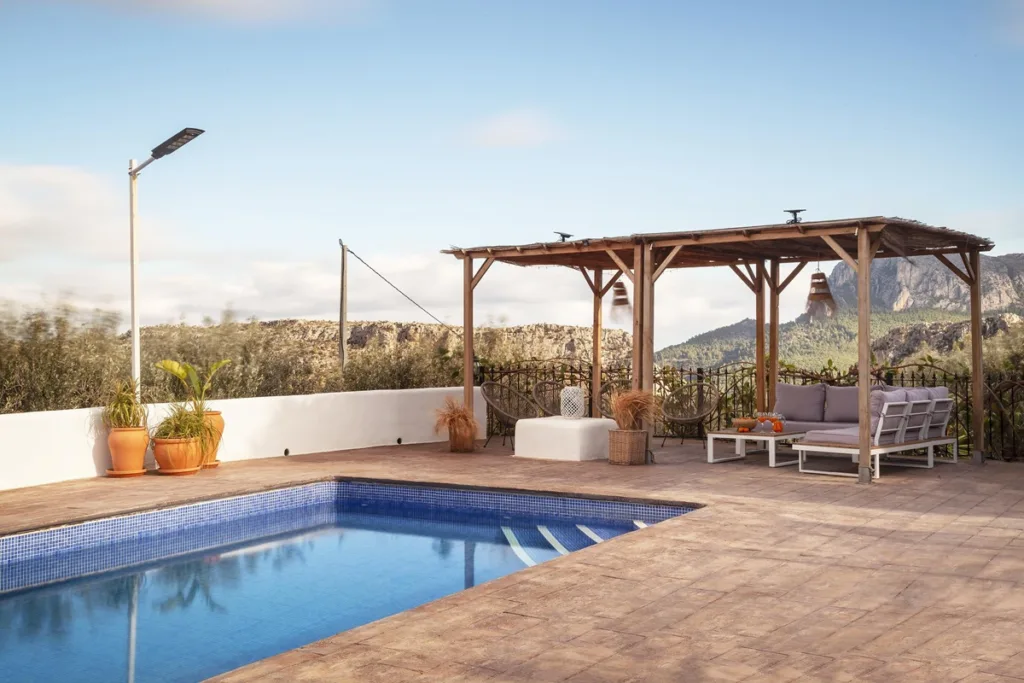 Piscina, pérgola y hamacas en la terraza de una casa rural