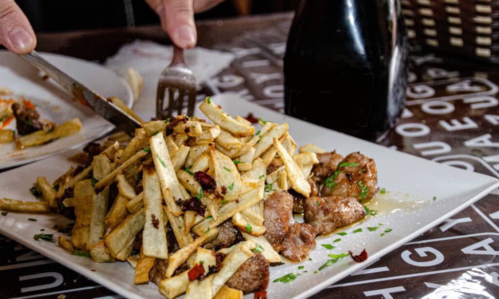 Carne de fiesta con patatas fritas, comida de guchinche.