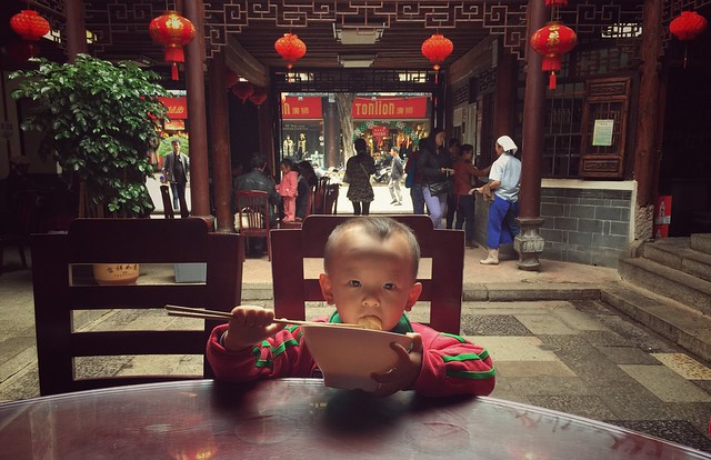 Niño comiendo tallarines en un restaurante en China