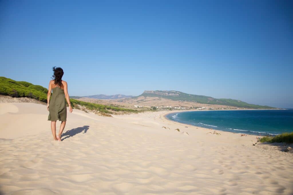 Mujer caminando por la duna de Bolonia, en Tarifa (Cádiz).