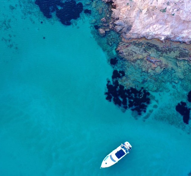 Plano cenital de un barco fondeando en una cala de Menorca